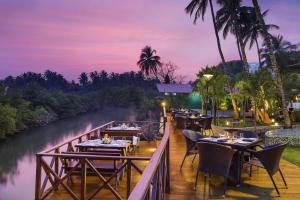 a restaurant on a bridge over a river at night at Lazy Lagoon, Baga A Lemon Tree Resort, Goa in Baga