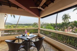 a balcony with a table and chairs on a balcony at Lazy Lagoon, Baga A Lemon Tree Resort, Goa in Baga