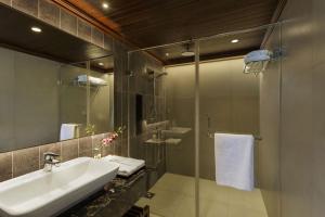 a bathroom with a sink and a glass shower at Lazy Lagoon, Baga A Lemon Tree Resort, Goa in Baga