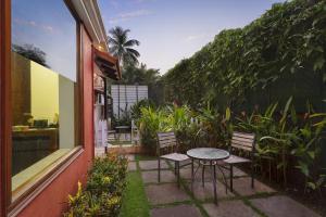 a patio with a table and chairs and plants at Lazy Lagoon, Baga A Lemon Tree Resort, Goa in Baga