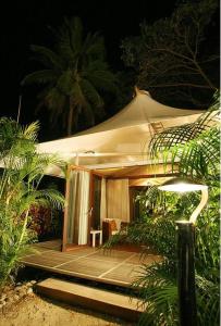 uma tenda com uma mesa e uma cadeira em frente em The Fiji Orchid em Lautoka