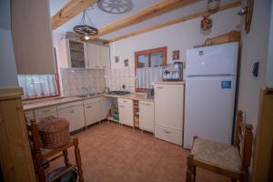 a kitchen with a white refrigerator and white cabinets at ZSUZSI-LAK in Sub Cetate