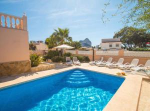 a swimming pool with lounge chairs and a house at Villa Nerea - Plusholidays in Calpe