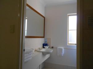 a white bathroom with a sink and a mirror at Augusta's Georgiana Molloy Motel in Augusta