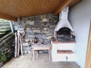 uma cozinha exterior com um fogão e uma mesa em La guérite du Locum em Meillerie