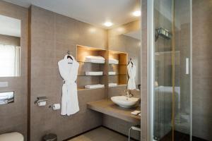 La salle de bains est pourvue d'un lavabo et d'une douche. dans l'établissement Four Elements Perm, à Perm