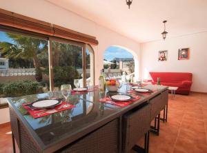 a dining room with a table and a red couch at Villa Nerea - Plusholidays in Calpe