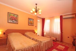 a bedroom with two beds and a chandelier at Family Hotel Silvestar in Veliko Tŭrnovo