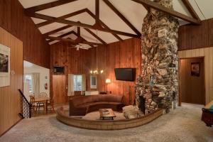 a living room with a couch and a stone fireplace at 25A Villarreal Retreat in Wawona