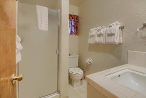 a white bathroom with a toilet and a sink at 25A Villarreal Retreat in Wawona +17 photos