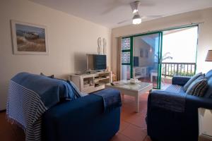 Sala de estar con 2 sofás azules y TV en 18 The Shades Umhlanga Rocks, en Durban
