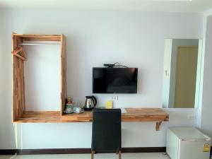 楠府的住宿－Nan Panwa Hotel，客房设有书桌和墙上的电视