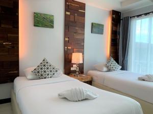 楠府的住宿－Nan Panwa Hotel，白色墙壁客房的两张床