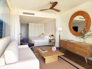 a living room with a white couch and a bed at H10 Imperial Tarraco 4 Sup in Tarragona