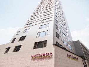 a tall white building with a butchery sign on it at Butterfly on Wellington Boutique Hotel Central in Hong Kong