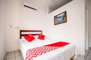 - une chambre avec un lit doté d'oreillers rouges dans l'établissement OYO Hotel Posada San Vicente, Huatulco, à Santa María Huatulco