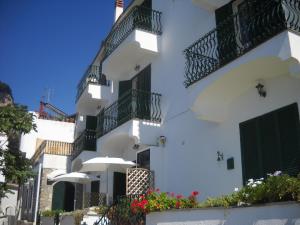 een wit gebouw met balkons en bloemen bij Le Cicale - Apartments in Conca dei Marini
