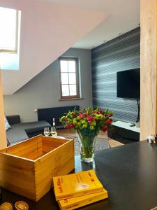 a living room with a vase of flowers on a table at Apartamenty Lemon Pepper in Jelenia Góra