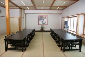 a conference room with black tables and chairs at Kogetsukan in Shika