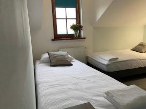 two beds in a small room with a window at Apartamenty Lemon Pepper in Jelenia Góra