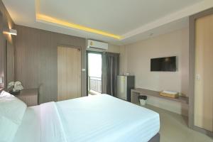 a bedroom with a large white bed and a television at Sleep Hotel Bangkok in Bangkok