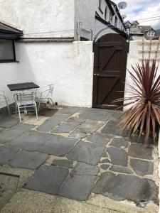 a patio with a table and a wooden door at Tyan, Ambleside in Ambleside