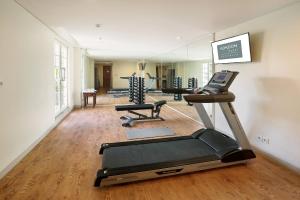 a gym with several treadmills and a mirror at Kokoon Hotel Surabaya in Surabaya
