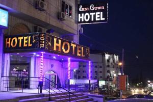 un hôtel avec des lampes de néon dans une ville la nuit dans l'établissement Sara Crown Hotel, à Irbid