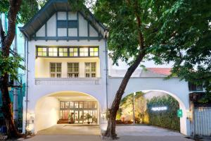 a white and blue house with an archway at Kokoon Hotel Surabaya in Surabaya