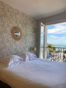 1 dormitorio con cama y ventana grande en Hôtel Les Baigneuses de Biarritz, en Biarritz