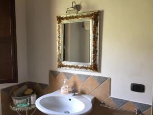 a bathroom with a sink and a mirror on the wall at Il Casale di Aurora Country House in Colmurano