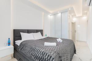een witte slaapkamer met een bed met een handdoek erop bij Rent like home - Karolkowa 28A in Warschau
