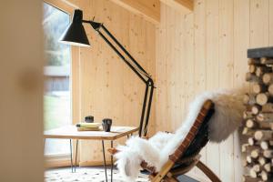 eine Lampe in einem Zimmer mit einem Tisch und einem Stuhl in der Unterkunft Ferienhaus Alpen Lodge und die Gams in Neurur