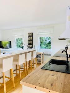 een keuken met witte muren en een houten tafel en stoelen bij Ferienhaus No. 4 in Perl