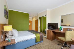a bedroom with a bed and a desk and a television at Holiday Inn Leamington Spa - Warwick, an IHG Hotel in Leamington Spa