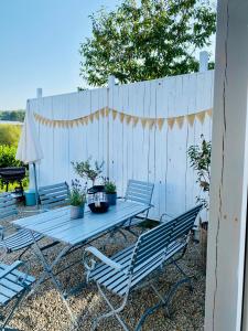 een picknicktafel met 2 stoelen en een hek bij Ferienhaus No. 4 in Perl