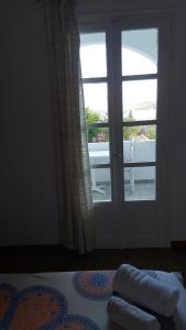 een kamer met een raam en een bed met 2 handdoeken bij Giorgia Lodging in Parikia