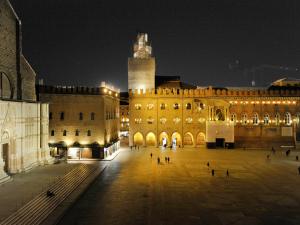 un grande edificio con una torre dell'orologio di notte di UR-NEST Dolfi a Bologna