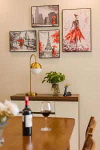 une table avec une bouteille de vin et un verre de vin dans l'établissement Troy House - Vinhomes Dcapitale - Cau Giay, à Hanoï