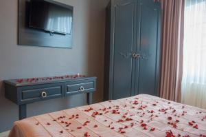 a bedroom with a bed and a dresser with red roses on it at Room Room Hotel in Sapanca