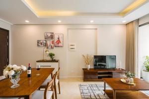 une salle à manger avec une table et une télévision dans l'établissement Troy House - Vinhomes Dcapitale - Cau Giay, à Hanoï