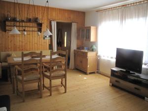 eine Küche und ein Esszimmer mit einem Tisch und einem TV in der Unterkunft Ferienhaus Edersee in Vöhl