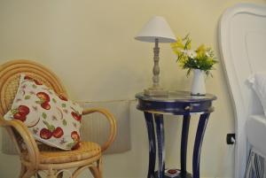 un tavolo con una lampada e una sedia con un cuscino di Il Giardino del Tè a Barletta