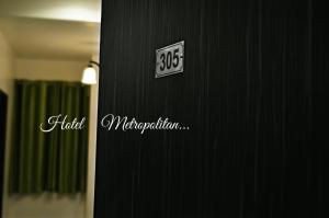 a clock on the side of a black wall at Hotel Metropolitan in Jaipur