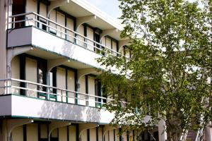 an apartment building with balconies and a tree at Premiere Classe Compiegne - Jaux in Jaux