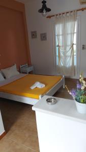 una camera con un letto con una coperta gialla di Giorgia Lodging a Paroikia