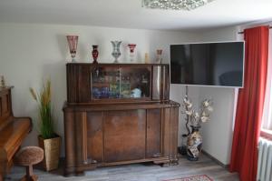 un gran armario de madera con TV en una habitación en Ferienhaus Köhler en Marienberg