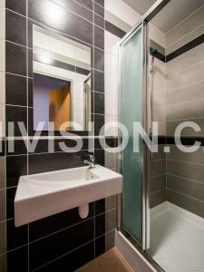 La salle de bains est pourvue d'un lavabo et d'une douche. dans l'établissement Penzion Topas, à Bylnice