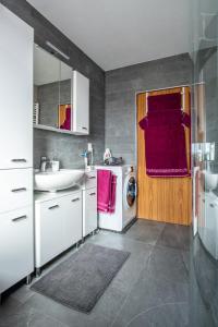 a bathroom with a sink and a washing machine at Ferienwohnung Bichler in Altötting