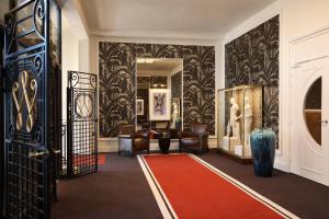 a hallway with chairs and a red carpet at Hôtel Barrière Le Westminster in Le Touquet-Paris-Plage